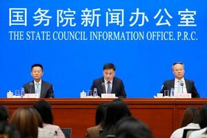 記者会見する中国人民銀行の潘功勝総裁(中央)ら=22日、北京(共同)
