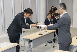 柏崎市の桜井雅浩市長(右)に、廃炉を含め検討するなどとした文書を手渡す東京電力の小早川智明社長=8月22日、柏崎市役所