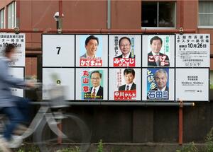 6人の候補者のポスターが並ぶ上越市長選の掲示板。当選には有効投票総数の4分の1以上の法定得票数が必要となる=上越市