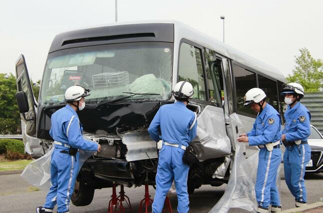 事故現場から移動されたマイクロバスにビニールをかける警察官ら＝６日午後３時１５分、福島県