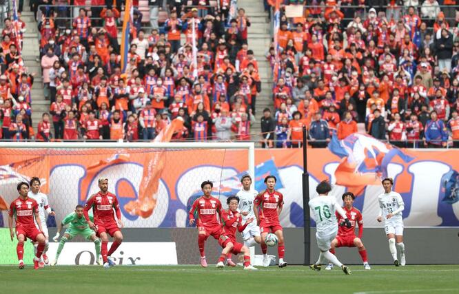 前半、ホーム開幕戦に詰めかけたサポーターの声援を背に守る新潟の選手＝７日、デンカビッグスワンスタジアム