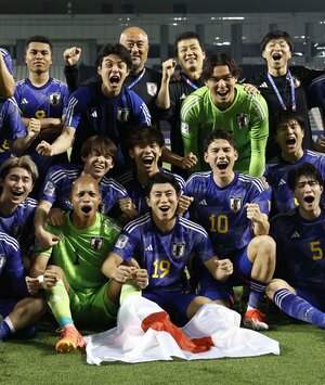 イラクに勝利し8大会連続の五輪出場を決め、笑顔で写真に納まる細谷(下段中央)らU―23日本代表=4月29日、ドーハ(共同)
