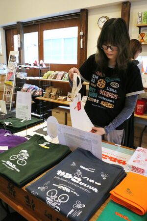 弥彦競輪場のロゴなどをあしらったTシャツなどのグッズ=新潟市中央区古町通3