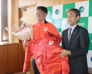 ミラノ・コルティナ冬季五輪で着用したウエアを胎内市に寄贈した男子スキークロスの須貝龍選手（左）＝２０日、胎内市役所
