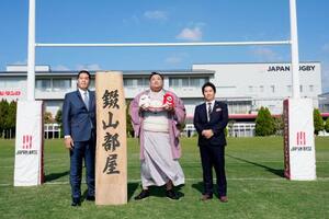 錣山部屋が宿舎を構えることになった日本ラグビー協会の強化拠点「ジャパンベース」で記念撮影する(左から)錣山親方と阿炎ら=27日、福岡市