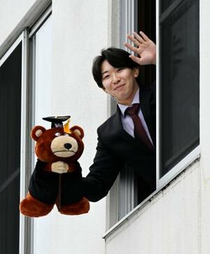 　楽天の寮に入り、自室から手を振る伊藤樹＝５日、仙台市