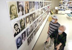 長岡空襲で犠牲になった鉄道教習生の遺影を見つめる遺族=29日、長岡市の長岡戦災資料館