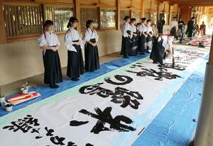 書をしたためる新潟第一高校の生徒=21日、新潟市中央区の護国神社