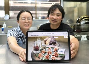 みんなのハムのＥＣサイトをＰＲする春日惇也さん（右）と妻の友美子さん＝長岡市西川口