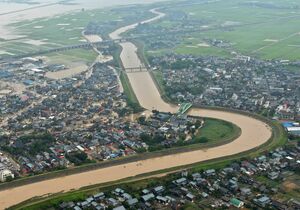 7.13水害で堤防が決壊した旧中之島町の刈谷田川。右岸は見附市今町=2004年7月14日(新潟日報社ヘリから)