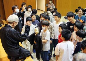 人形浄瑠璃の上演後、人形の動かし方などの説明を受ける児童=阿賀町鹿瀬
