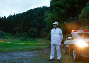 土砂崩れがあった現場近くで規制線を張り、警戒する警察官=5日午後5時34分、石川県小松市
