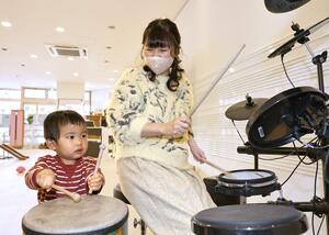 子どもとドラムをたたく「まーち」の佐藤弥生代表=上越市本町3