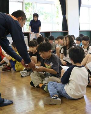 防災メモを受け取る児童ら=上越市五智4