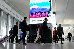 北京首都国際空港の大型画面に表示された富士山のイラスト=16日(共同)