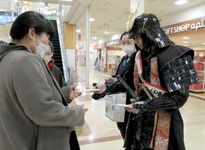 来店者に電子申告をPRする越後上越上杉おもてなし武将隊=2月5日、上越市富岡