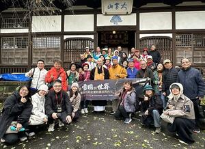 普済寺を訪れ、記念撮影する台湾からの訪日グループの人たち＝村上市大場沢