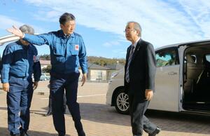 東京電力廃炉資料館に到着し、小早川智明社長(左)の出迎えを受ける花角英世知事=18日午前9時30分前、福島県富岡町