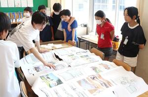 新潟工科大生から校舎の設計案の説明を受ける子どもたち=柏崎市新道