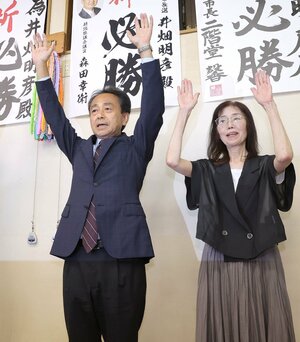 3選を決め、万歳をする井畑明彦氏=14日午後11時ごろ、胎内市本町