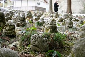 　岩手県陸前高田市の普門寺に並ぶ石像。震災遺族らがつくった＝１月