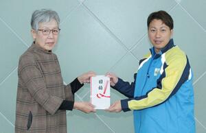 加藤美也子会長に義援金を託す本間寛道社長（右）＝糸魚川市のビーチホールまがたま