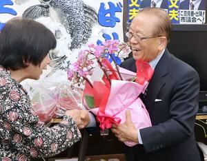 12回目の当選を決め、笑顔を見せる本城文夫さん(右)=4月21日、上越市南本町3