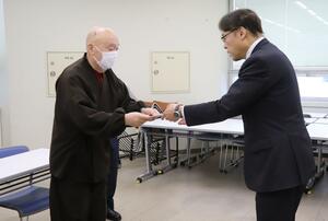 米坂線の早期復旧の要望書と追加の署名を県に提出した地元団体のメンバー(左)=2月10日、県庁