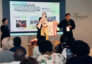 徳島の人形芝居「阿波木偶箱まわし」の歴史を説明する保存会顧問の辻本一英さん(奥右)=1日午後、大阪市此花区の夢洲