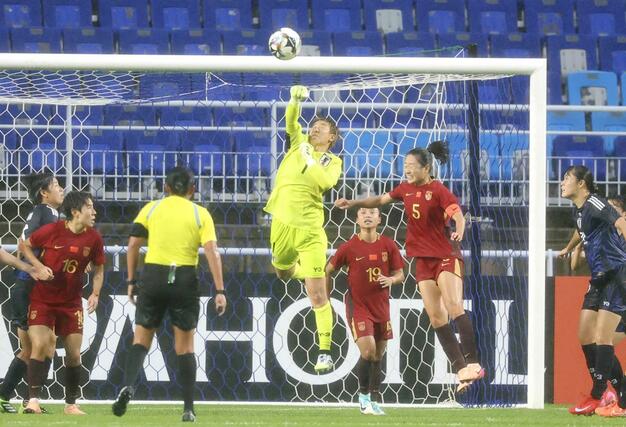 日本－中国　後半、パンチングするＧＫ平尾（中央）＝水原（共同）