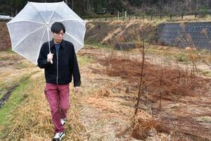 「二重被災」した田んぼの周辺を歩く山下祐介さん=3日、石川県輪島市町野町