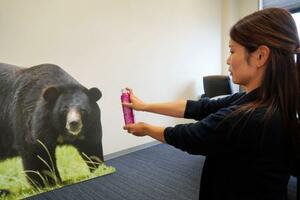 　クマ用スプレー「熊一目散」の使い方を説明するバイオ科学の社員＝１１日、徳島県阿南市