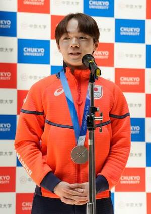 中京大で開かれたミラノ五輪報告会であいさつする鍵山優真=15日、名古屋市