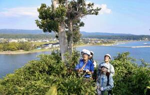 石川県珠洲市の見附島で調査する柳井清治氏(手前左)ら研究チーム=9月