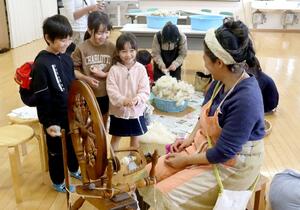 糸車を使った羊毛の毛糸づくりを体験する子どもたち=5月4日、新潟市南区東笠巻新田