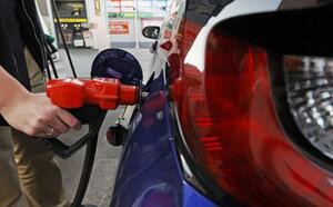 ガソリンスタンドで給油する人=東京都内