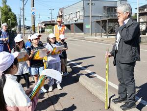 ７・１１水害の当時の様子について、地元住民から説明を受けた春日新田小の４年生ら＝上越市春日新田２