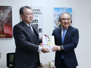 3000万円の目録を手にする牧田社長(右)と関口市長=1月24日、十日町市役所