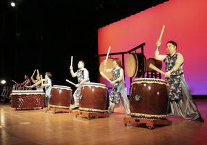 迫力のばちさばきを披露する「越後・親不知太鼓」のメンバー＝糸魚川市の青海総合文化会館