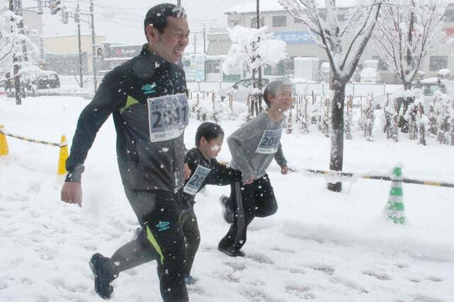 手をつないでゴールを目指したランナー＝１月１日、三条市