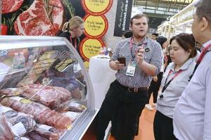 中国最大級の食品見本市で、自国産牛肉を中国のバイヤーに売り込むオーストラリアの業者(左)=5月、中国上海市