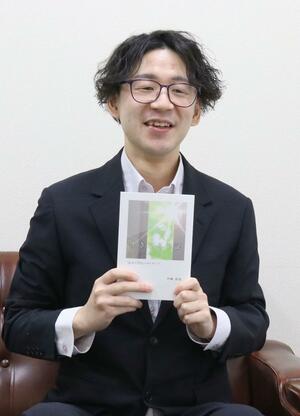 増刷された著書を紹介する平岡良亮さん=三条市須頃2の新潟日報三条総局
