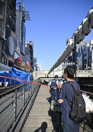 消防隊員2人が犠牲になった大阪・道頓堀のビル火災現場で手を合わせる男性=19日午後