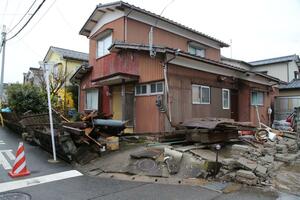 地面が隆起し、車庫が倒壊した住宅=1月3日、新潟市西区小針南