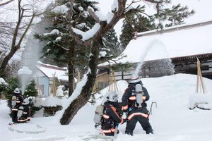 日光寺での消防訓練で、本堂に放水する消防隊員=糸魚川市の日光寺