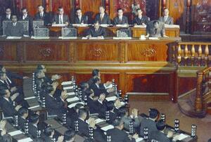 沖縄関連法案が可決し、頭を下げる佐藤栄作首相ら閣僚と拍手する自民党議員=1971年12月14日