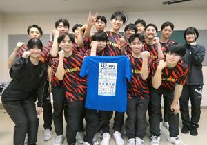 企業ロゴの入った応援Tシャツを手にする佐渡高校男子バレーボール部の選手ら=佐渡市石田