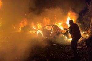 1日、レバノンの首都ベイルートで、イスラエルによる空爆で燃え上がった車の火を消す消防士(AP=共同)