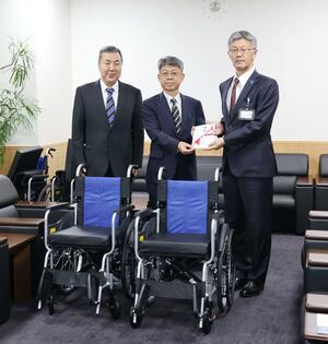 車椅子を寄付した柏崎管工事業協同組合の堀井徹副理事長(中央)と飯塚豊理事(左)=柏崎市役所