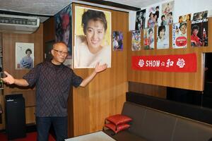 自慢のコレクションが並ぶ店内を紹介するオーナーの三部寛さん=三条市本町1のスナック「Showa」